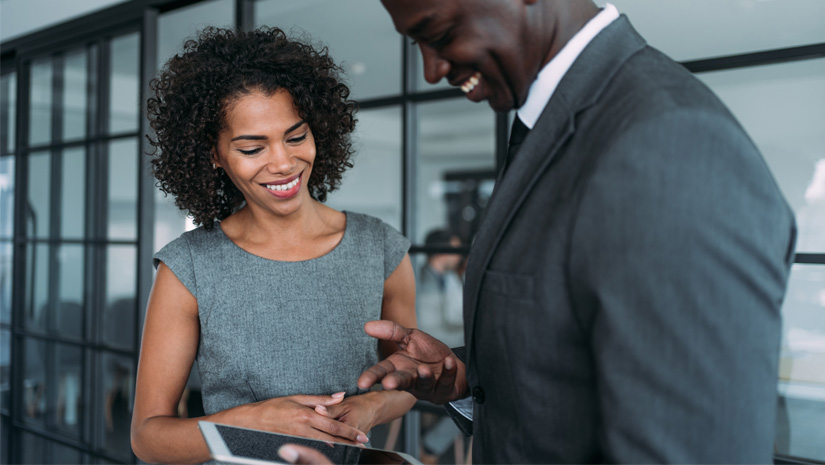 Shot of two coworkers having a discussion in modern office