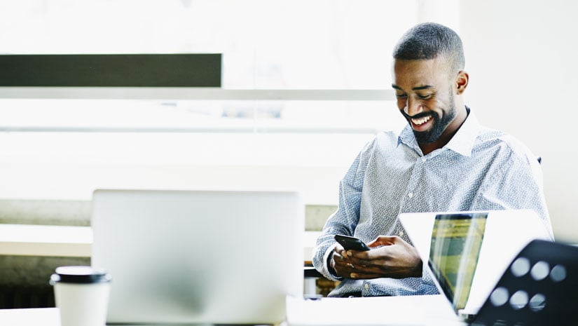 Smiling Businessman Working on Smartphone