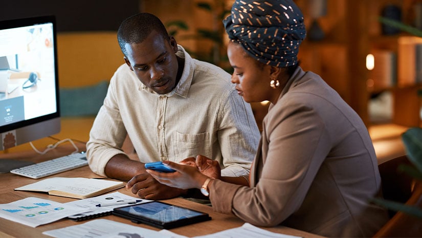 Woman with man at desk with phone