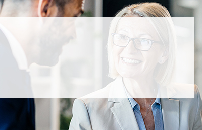 A woman in glasses discusses her business transition plans with her CLA advisor.