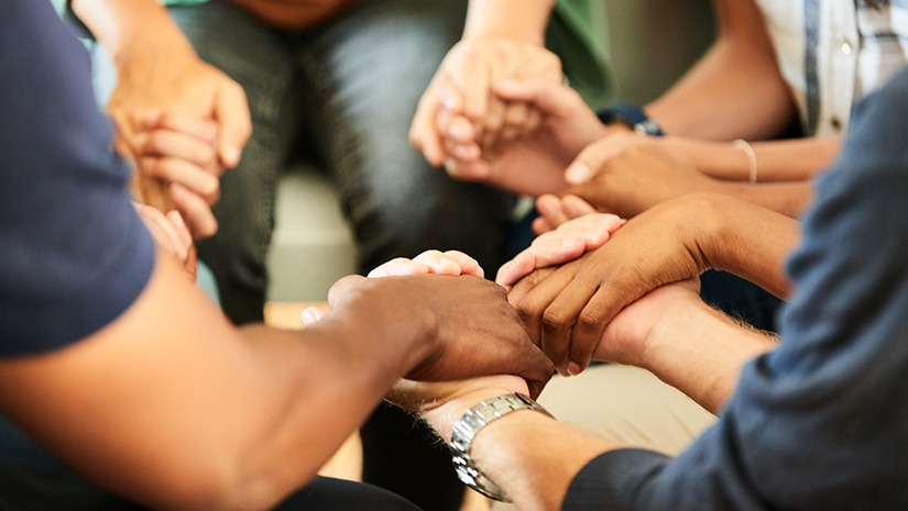 People holding hands together during a support group meeting