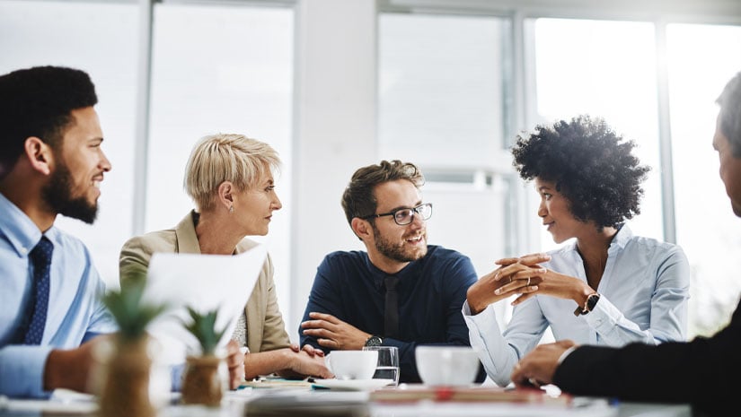 Cropped shot of a diverse group of businesspeople sitting together and having a meeting in the office.