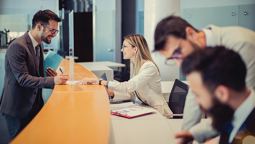 Young man is standing at a bank counter