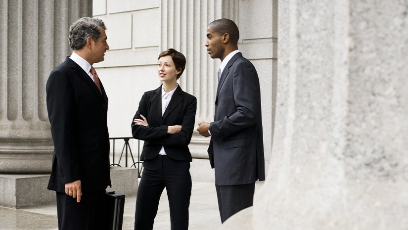 Business people talking outside of a government building.