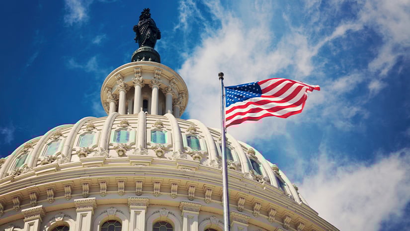 Capitol building with American flag waving in the breeze