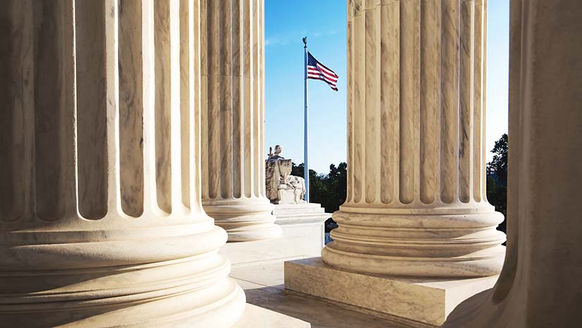 American Flag Seen Through Columns