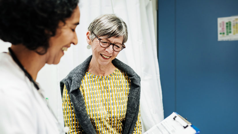 Doctor showing paperwork to mature patient.