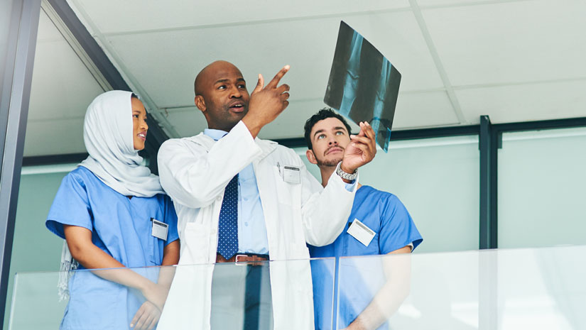 Shot of a team of doctors discussing the results of an xray in a hospital.