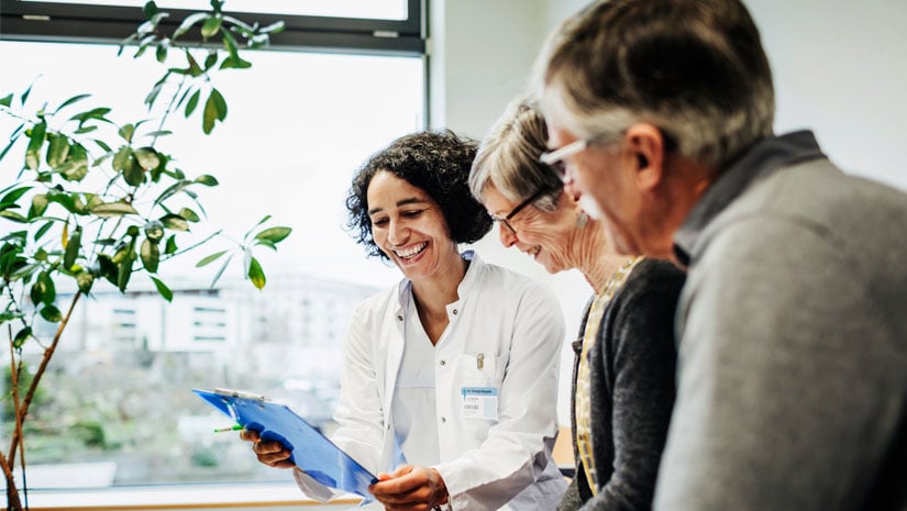 Doctor talking to elderly couple.