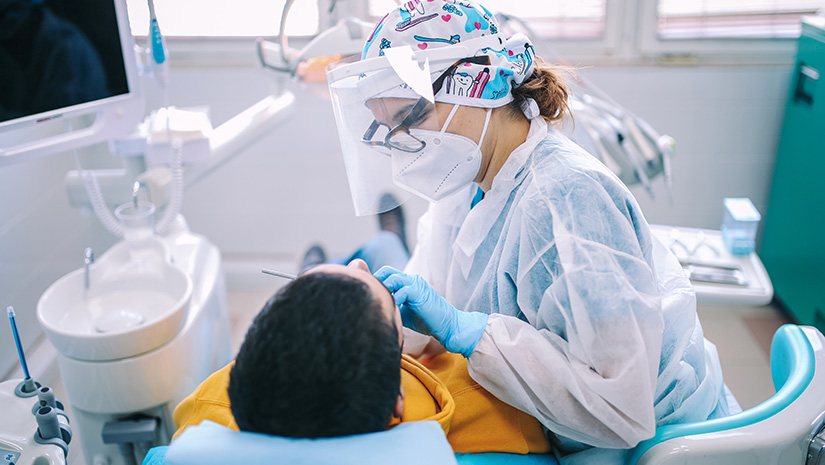 Female dentist checking up patient teeth