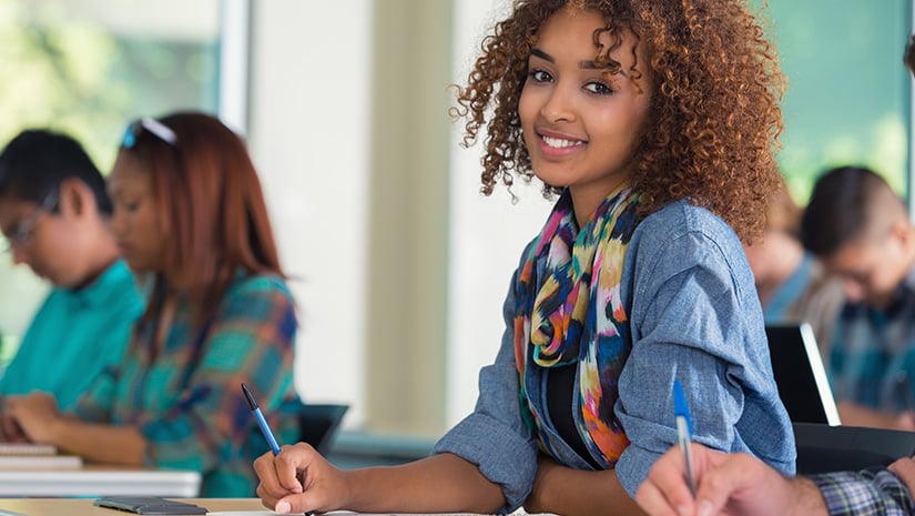 Beautiful female teenage college student in classroom