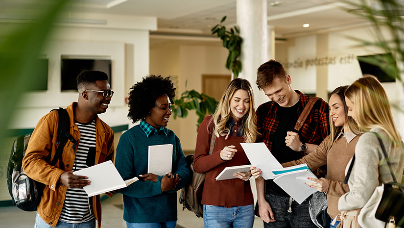 Group of happy students looking at exam results while standing at universit