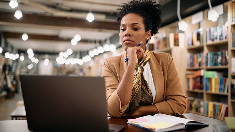 Mid adult black university professor working on laptop