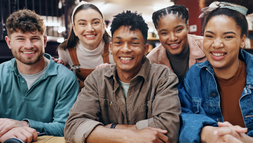 Portrait of student friends in university library together