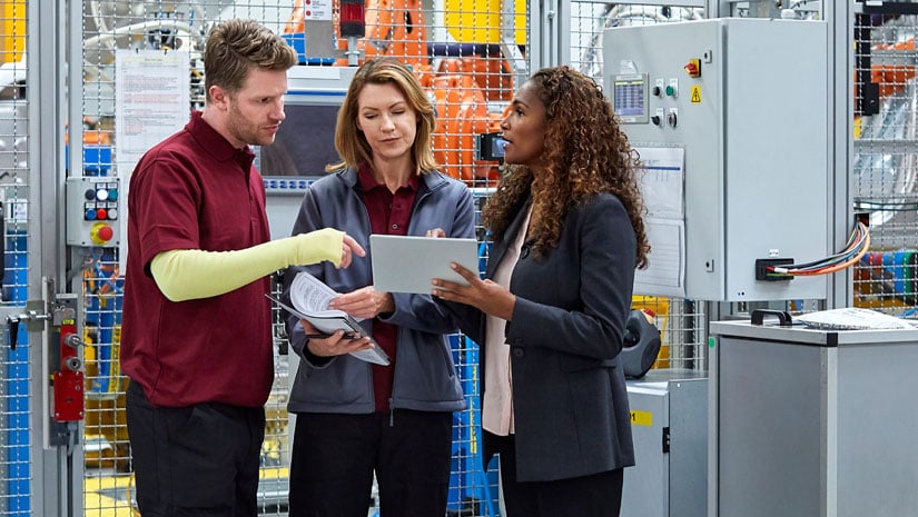 Full length of engineers discussing in car plant.