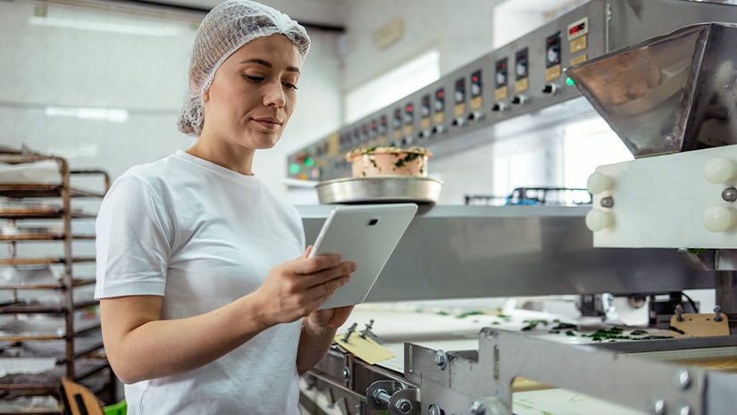 Female Baker With Digital Tablet in the Bakery