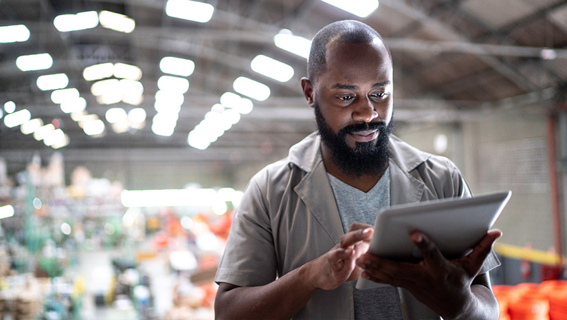Focused manager using tablet in factory