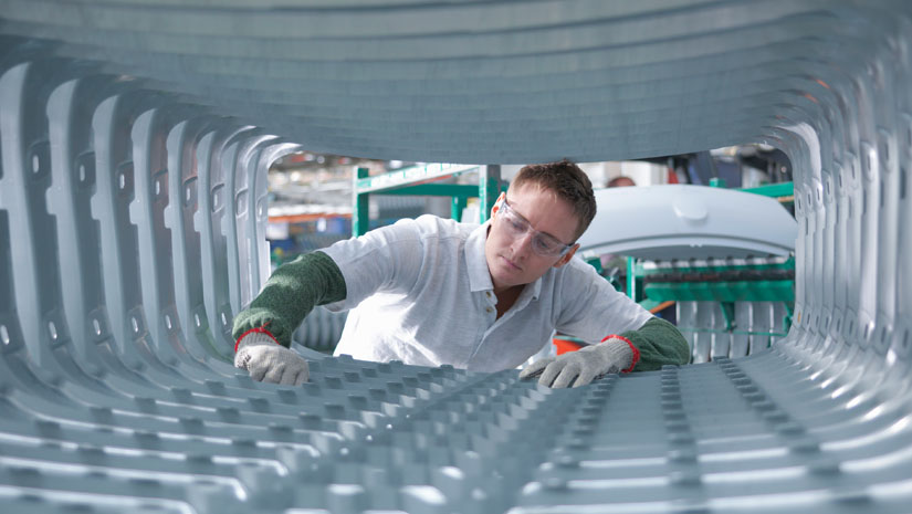 Man cleaning machinery in factory.