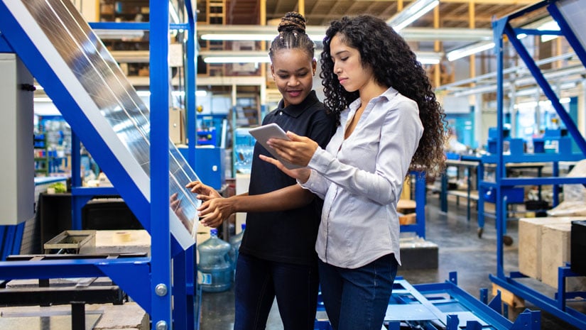 Female engineer showing the production plan to a worker on her digital tablet.