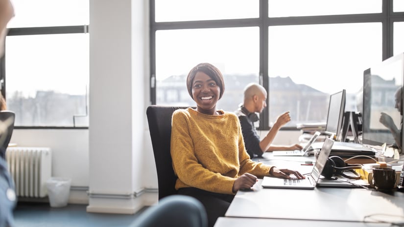 Colleagues talking in open office setting