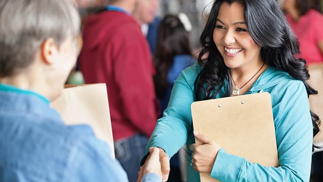 Female volunteer greeting woman at donation facility