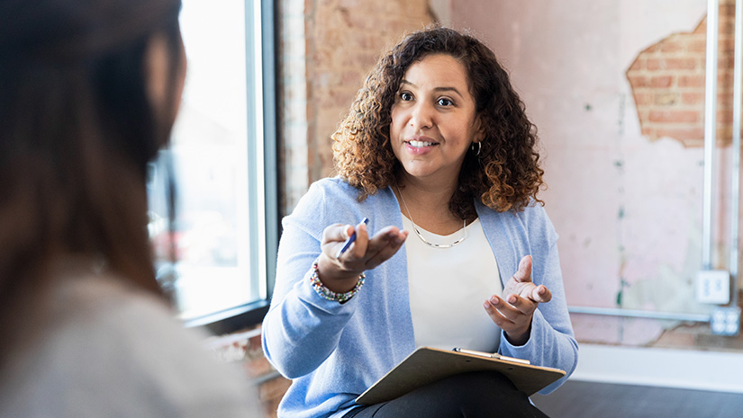 Meeting oneonone female therapist gestures toward unrecognizable woman