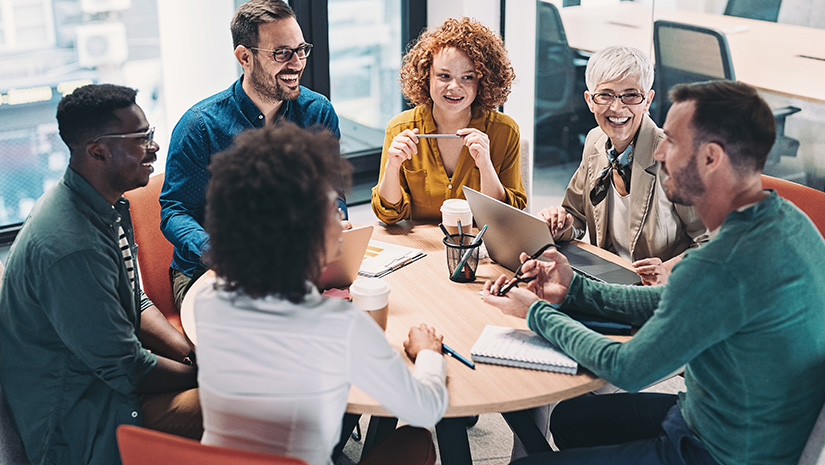 Mixed group of business people sitting around a table and talking