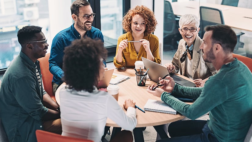 Mixed group of business people sitting around a table and talking