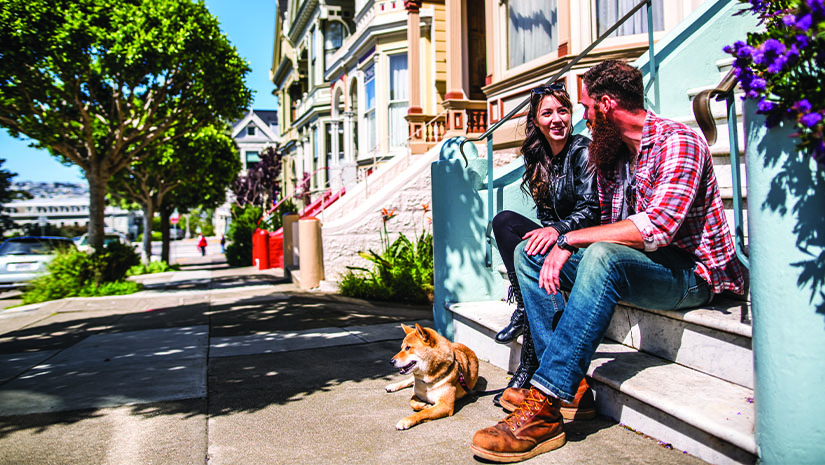 A couple with a dog on a city walk