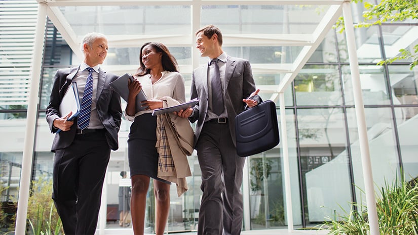 Business people walking out of office building together