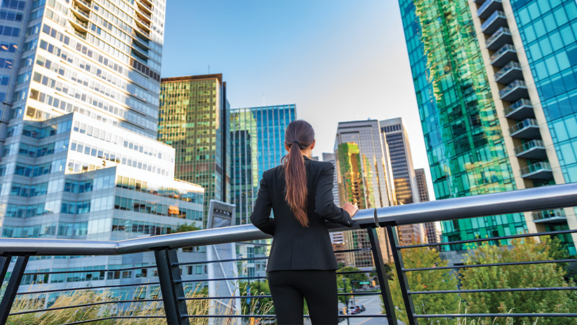 Business woman in city center looking at view of skyline skyscrapers