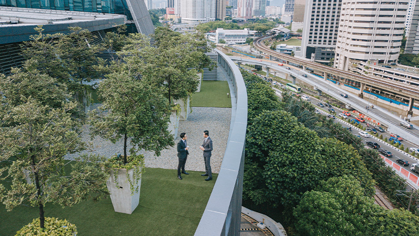 Businessmen talking on roof top garden outside office building