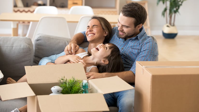 Laughing family spend time having fun at new home