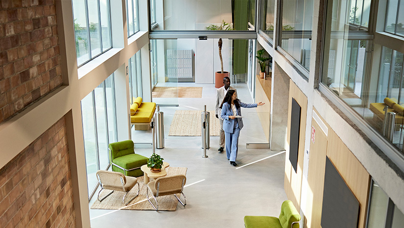 Realtor Leading Client Through Modern Office Building Lobby