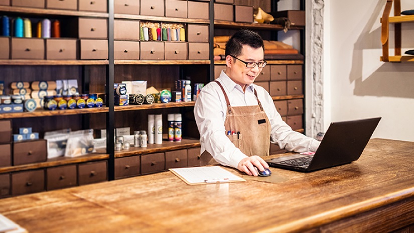 Shoe Shop Owner Working at Counter