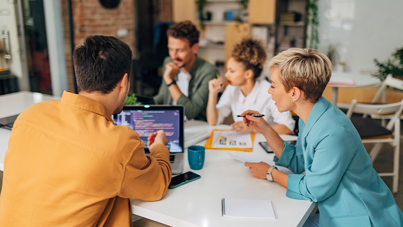A male programmer shows a female colleague a coding