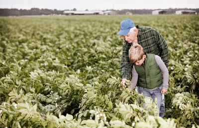 Farmer with Grandson in Field