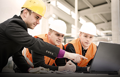 Architect-Pointing-Laptop-Two-Construction-Workers