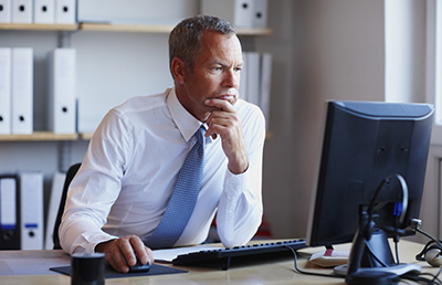 Businessman Concentrating Hand On Mouse Reviewing Screen