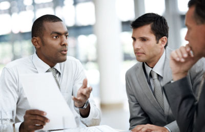 Businessman Explaining Papers to Colleages