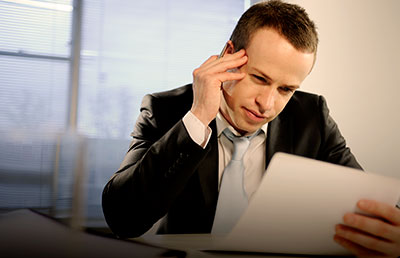 Businessman Reviewing Document Thinking Hard