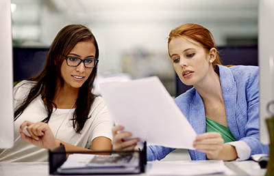 Two-Businesswomen-Reviewing-Document-Computers.jpg