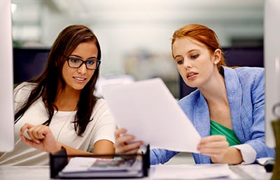 Two-Businesswomen-Reviewing-Document-Computers.jpg