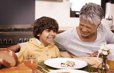 Grandmother with Grandson at Dinner Table